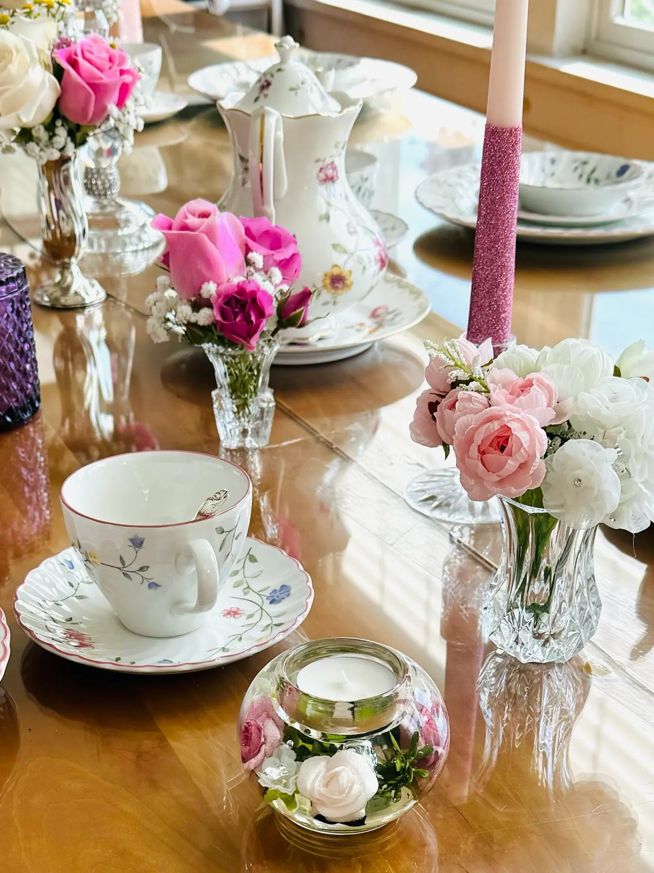 Gluten-free tea party place setting with pink taper candles, fresh roses and vintage floral china